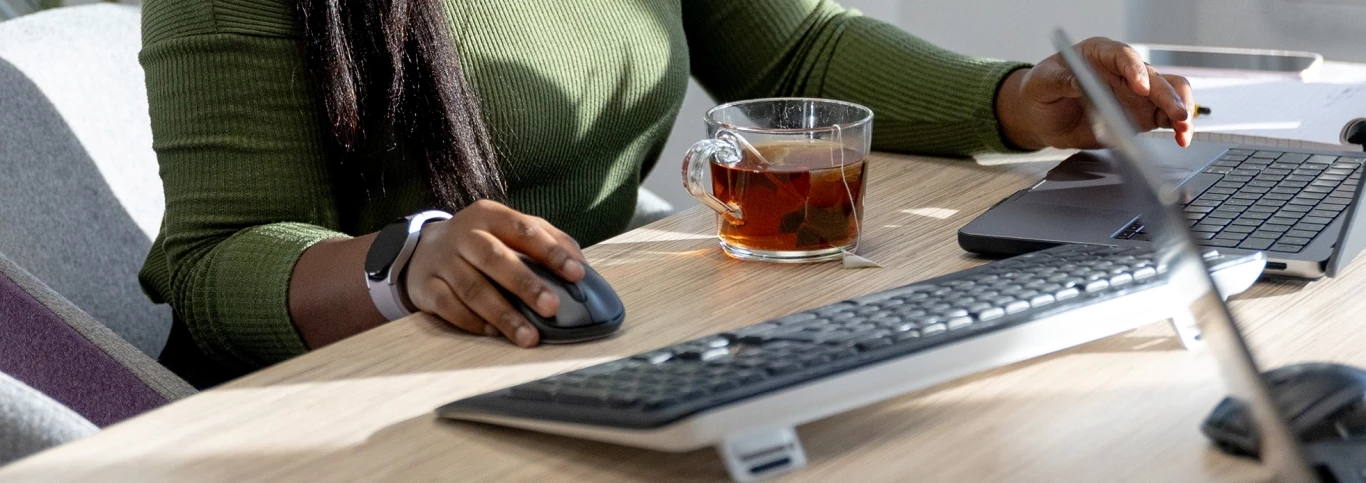 Medewerkster Florisoft achter een bureau met een groot glas thee